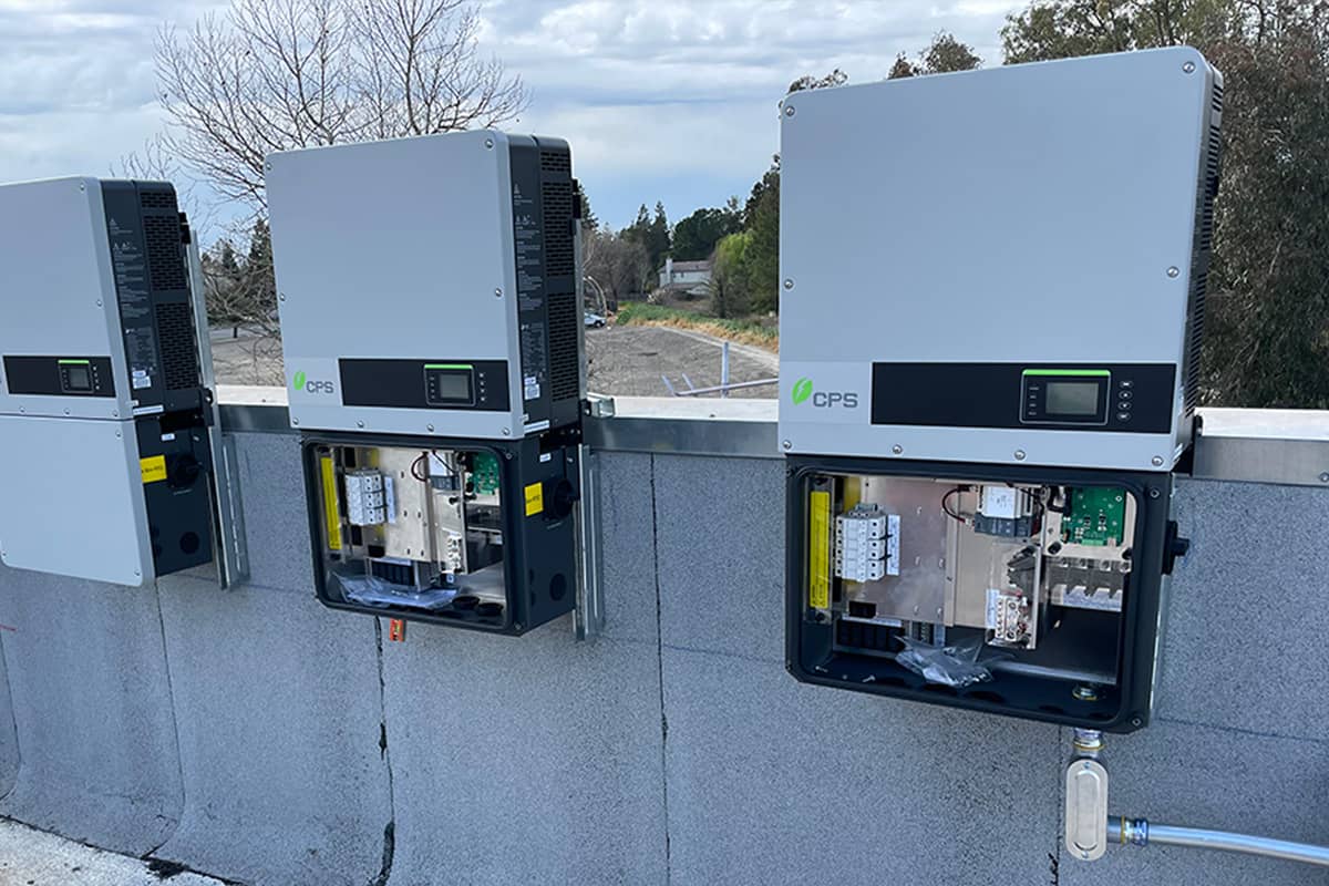 solar inverters on rooftop with cloudy sky